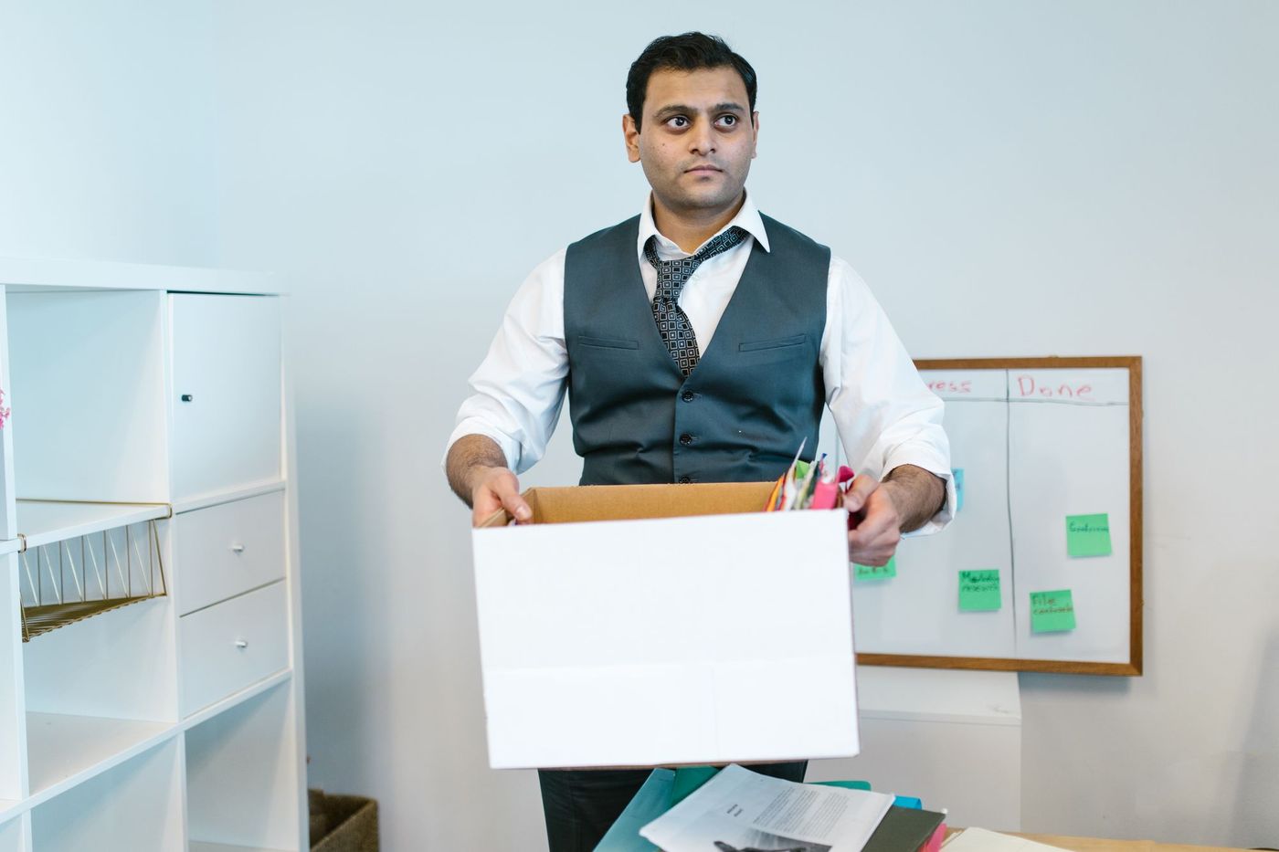 An office worker packing desk items into a box during a relocation