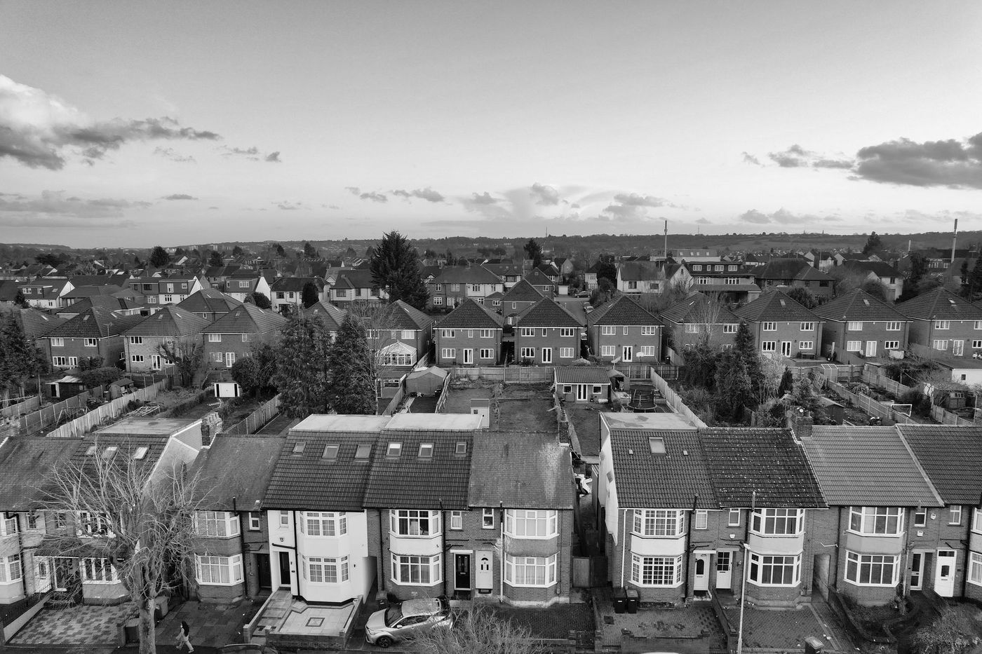 Aerial view over rows of semi-detached suburban houses and their back gardens
