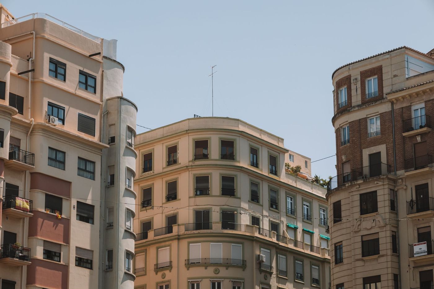 Cream and terracotta apartment buildings against a pale sky in Valencia